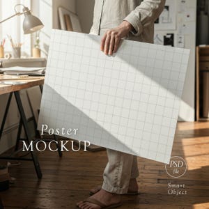 May include: A person holding a large white poster mockup with a grid pattern. The words "Poster MOCKUP" are printed on the poster. The image also includes a "PSD file" and "Smart Object" label.