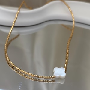 Golden necklace with white clover pendant – lucky charm jewelry for women – gift idea – filigree chain gold-plated