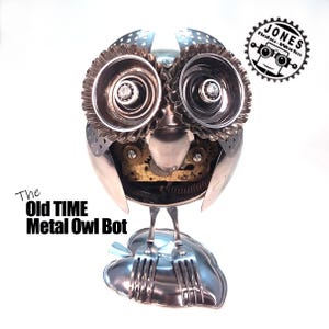 May include: A handcrafted metal owl sculpture titled "The Old Time Metal Owl Bot." The owl features repurposed metal components, including spoons, forks, and gears, with a leaf-shaped base. The sculpture has a mechanical aesthetic.