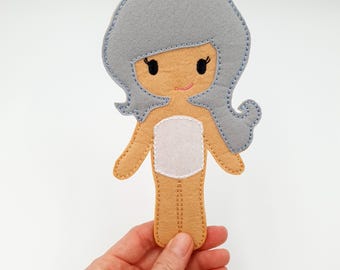 May include: A felt doll with gray hair, a white torso, and tan arms and legs. The doll is designed for children to dress up and play with.