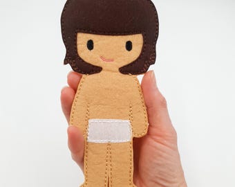 May include: A felt doll with brown hair, a white diaper, and a smiling face.