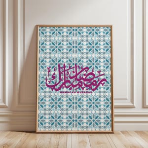 Puede incluir: Lámina artística enmarcada con un patrón geométrico en tonos azules y grises. La obra presenta caligrafía árabe magenta y el texto en inglés "Ramadan Mubarak" debajo, ideal para celebraciones del Ramadán.