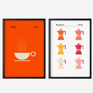 May include: Two framed Bauhaus-style art prints. The left print features a white coffee cup on an orange background with the text "Bauhaus 1919". The right print displays six colourful coffee pot illustrations with the text "Bauhaus 1919".