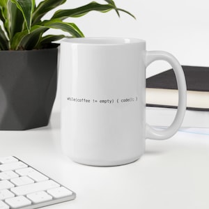 May include: White ceramic mug with black text that reads "while(coffee != empty) { code(); }"