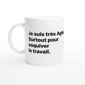 Könnte beinhalten: Weißer Keramikbecher mit gebogenem Henkel. Der Becher hat einen schwarzen Text, der lautet: "Je suis très Agile. Surtout pour esquiver le travail."