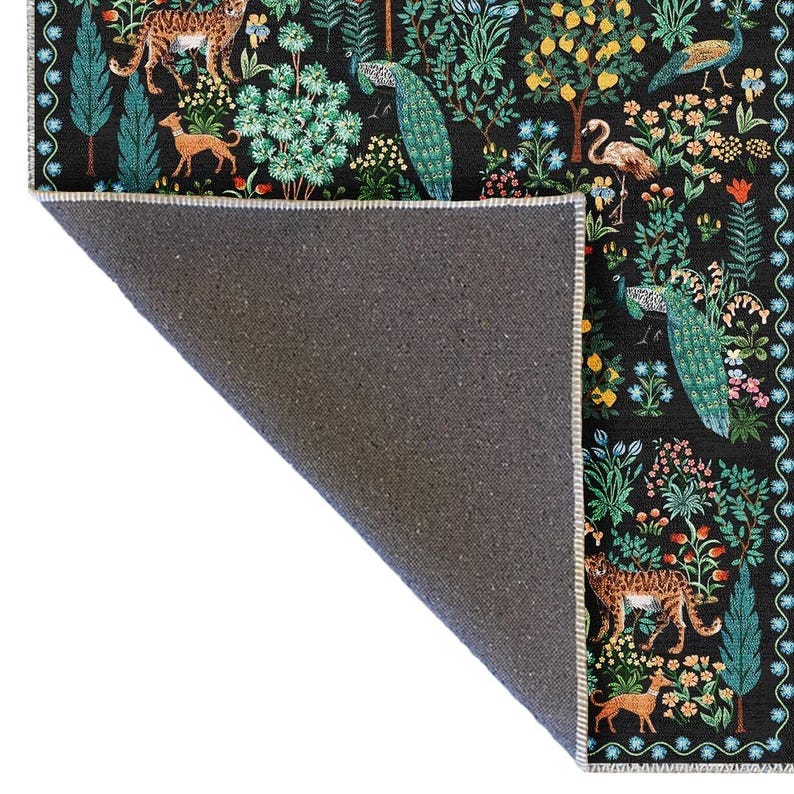 May include: A black area rug featuring a detailed botanical design with peacocks, leopards, dogs, and various flora. The rug's border has a repeating pattern. The rug's backing is a dark gray color.