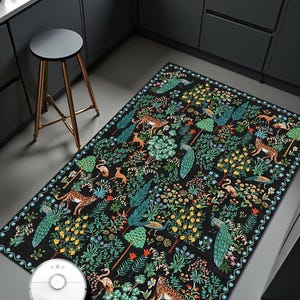 May include: A rectangular black rug with a detailed pattern of animals, trees, and flowers. The design includes leopards, peacocks, and flamingos among lush foliage. The rug is placed on a gray floor in a kitchen setting.