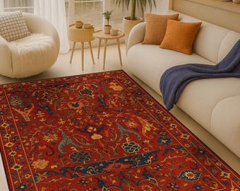 May include: A rectangular red area rug with an intricate floral and geometric pattern. The rug features a dark blue border and accents of yellow and blue. It is placed in a living room setting.