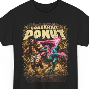 Può includere: Una t-shirt nera con una stampa grafica che raffigura un personaggio muscoloso in fuga da un dinosauro piumato blu e rosa. Il testo "GODDAMNIT DONUT" è stampato in grandi lettere gialle dall'aspetto usurato sopra la scena.