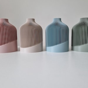 Può includere: Quattro vasi decorativi con un design a coste. I vasi sono rosa, beige, azzurro e verde.