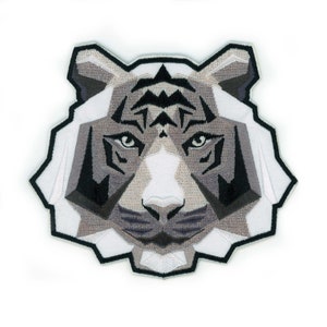 Può includere: Una toppa ricamata geometrica bianca e grigia con il viso di una tigre.