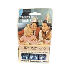 May include: A white ceramic mug with a black handle and the text "But First, Coffee" in a black, bold font. The mug is on a white surface.