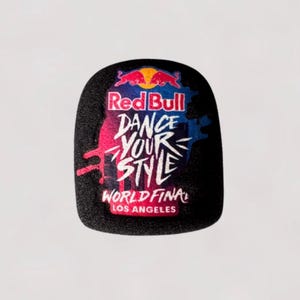 Puede incluir: Parche negro y redondeado con el logotipo de Red Bull y el texto "Red Bull Dance Your Style World Final Los Angeles". El diseño incluye detalles en rosa, azul y blanco.