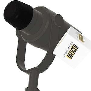 May include: A dark gray microphone mounted on a U-shaped stand with a white cube attached to the side. The cube features the text "CHIEF SWAG" in black and "OFFICER" in bold yellow letters on two visible sides of the white surface.