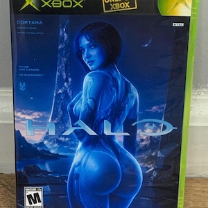 May include: A video game case for the Xbox game "Halo." The cover features a blue-toned image of a female figure with the word "HALO" in large letters. The case has the Xbox logo and the text "ONLY ON XBOX."