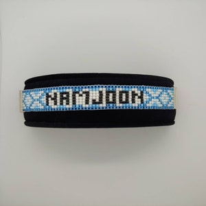 Puede incluir: Un collar de perro de cuentas negras con un patrón blanco y azul y el nombre "MAYSON" en cuentas negras.