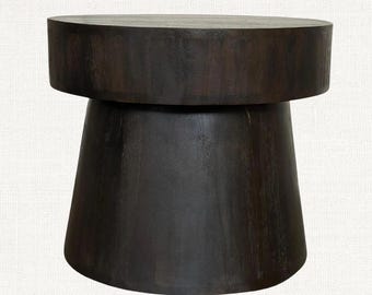 May include: A dark brown wooden side table featuring a cylindrical top section and a wider, tapered base. The piece is constructed from solid wood with a visible grain pattern, showcasing a smooth, matte finish throughout its entire structure.