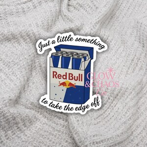 May include: A sticker featuring a blue and white Red Bull carton with six cans. The text "Just a little something to take the edge off" is written around the carton. The sticker also includes the text "GLOW & CHAOS".