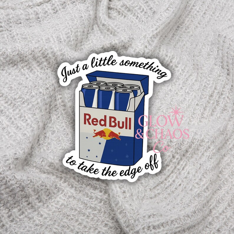 May include: A sticker featuring a blue and white Red Bull carton with six cans. The text "Just a little something to take the edge off" is written around the carton. The sticker also includes the text "GLOW & CHAOS".