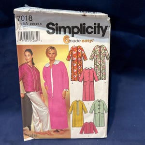 May include: A Simplicity sewing pattern package featuring a pink robe with a white collar, and other robe designs. The package includes the text "Simplicity" and "made easy!" with size information.