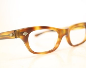 May include: A pair of tortoiseshell eyeglasses with a silver accent on the side.