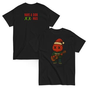 May include: Black t-shirts with Christmas-themed graphics. One shirt features the text "HAVE A SICK XX-MAS" in red and green. The other shirt displays a cartoon character wearing a Santa hat and playing a guitar, with the text "JINGLE BOI".