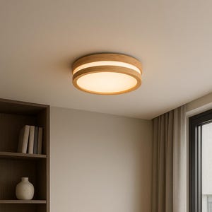 Op de afbeelding: Een ronde, houten plafondlamp met een warme, diffuse gloed. De lamp heeft een natuurlijke houten afwerking en een verzonken, verlicht midden. De kamer heeft een bureau, een boekenplank en muren in neutrale tinten.