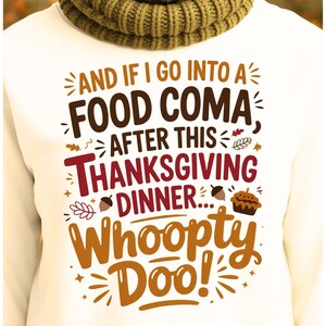 Może przedstawiać: Biała koszulka z długim rękawem z napisem "AND IF I GO INTO A FOOD COMA AFTER THIS THANKSGIVING DINNER... Whoopty Doo!" w kolorze brązowym, czerwonym i pomarańczowym. Widoczny jest również zielony, dziergany szalik.