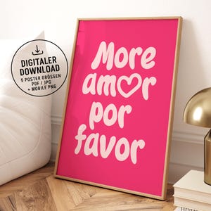 Könnte beinhalten: Gerahmtes pinkfarbenes Poster mit den Worten "More amor por favor" in weißer Schrift. Das Poster enthält auch ein digitales Download-Symbol und Text. Der Rahmen ist hellholzfarben.