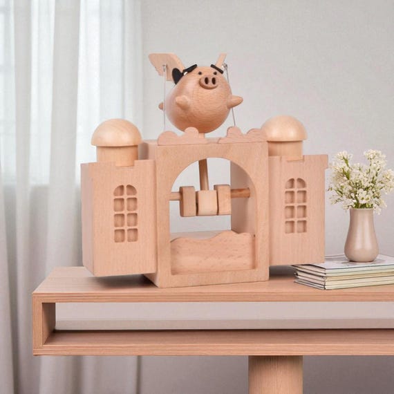 A wooden flying pig automaton — because someone spent real craft hours making 'when pigs fly' into a mechanical reality you can crank by hand.