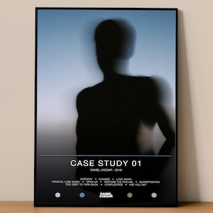 May include: Framed art print featuring a blurred silhouette of a person against a blue and white gradient background. The print includes the text "CASE STUDY 01" and the artist's name, "DANIEL CAESAR - 2019", along with a list of song titles.