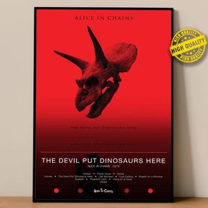 May include: A framed poster with a red background features a dinosaur skull illustration. The text "ALICE IN CHAINS" and "THE DEVIL PUT DINOSAURS HERE" are displayed. The poster includes a list of song titles and the year 2013.