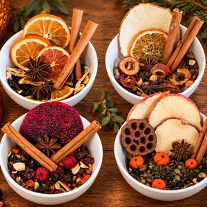 May include: Four white ceramic bowls filled with dried fruit, cinnamon sticks, and star anise. The bowls contain various combinations of dried orange slices, apple slices, dragon fruit, lotus pods, berries, and green tea leaves on a wooden surface.