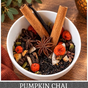 May include: A white bowl filled with a loose leaf tea blend containing black tea leaves, two cinnamon sticks, a star anise, a dark vanilla bean, green pumpkin seeds, coconut flakes, and small orange pumpkin-shaped pieces with the text PUMPKIN CHAI.