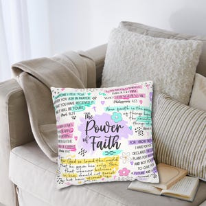 May include: A decorative cushion with the words "The Power of Faith" in a whimsical design. The cushion features a pastel colour palette with floral accents and inspirational quotes. It is placed on a beige sofa with other cushions.