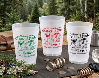 May include: Three frosted plastic cups featuring the text with love from CHARLESTON and Laura's Bachelorette. Each cup displays line art illustrations of a cocktail, beach umbrella, palm tree, sunglasses, and seashells in green, red, or black.