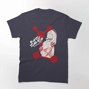 Peut inclure: T-shirt bleu marine avec une illustration blanche de style anime d'une personne aux longs cheveux, entourée de cercles rouges. Du texte japonais est également présent. Le motif est centré sur le devant du t-shirt.