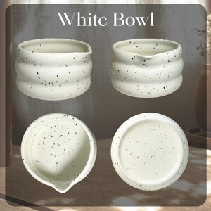 May include: Four views of a white bowl with a speckled design. The bowl has a rounded shape with a wavy, textured exterior. The text "White Bowl" is at the top of the image. The bowl has a small spout on one side.
