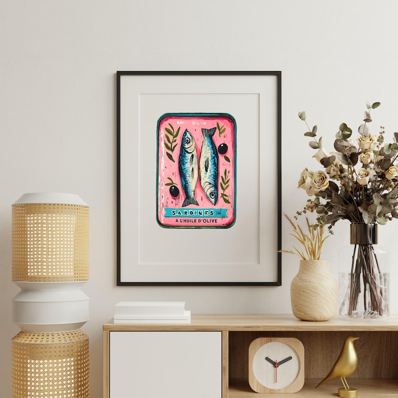 May include: A vintage-style illustration of a pink sardine can with two sardines and olives. The can has the text "SARDINES A L'HUILE D'OLIVE" on it.