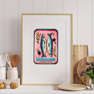 May include: A vintage-style illustration of a can of sardines in oil. The can is pink with blue and white fish and green leaves. The text on the can reads "SARDINES A L'HUILE D'OLIVE".