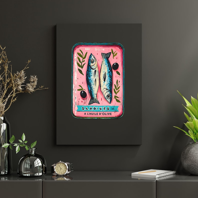 May include: A vintage-style illustration of a pink sardine can with two sardines and olives. The can has a blue border and the text "SARDINES A L'HUILE D'OLIVE" in black.