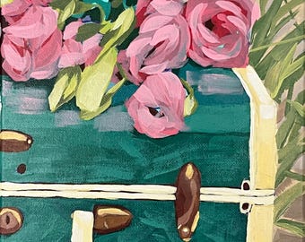 May include: An acrylic painting of a teal green vintage suitcase filled with pink flowers and green foliage. The suitcase has cream-colored trim and brown hardware. The artwork is on a canvas.