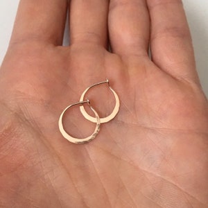 May include: A pair of small, hammered gold hoop earrings. The earrings are simple and elegant, and would make a great gift.