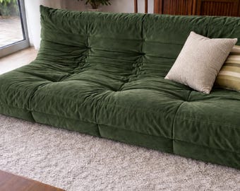 Sofá de suelo capitoné de terciopelo verde, sofá lounge de perfil bajo para una sala de estar acogedora.