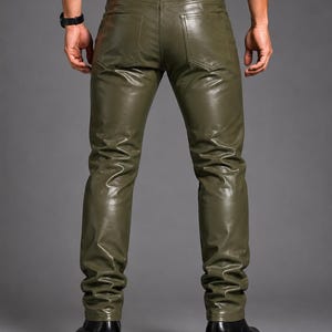 May include: Olive green trousers with a smooth, leather-like finish. These pants feature a classic five-pocket design, including two back pockets, a waistband with belt loops, and a button closure. The fit is slim through the legs with straight hems.