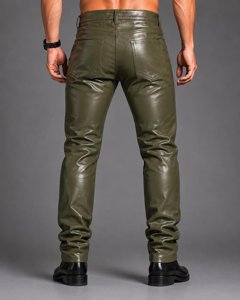 May include: Olive green trousers with a smooth, leather-like finish. These pants feature a classic five-pocket design, including two back pockets, a waistband with belt loops, and a button closure. The fit is slim through the legs with straight hems.