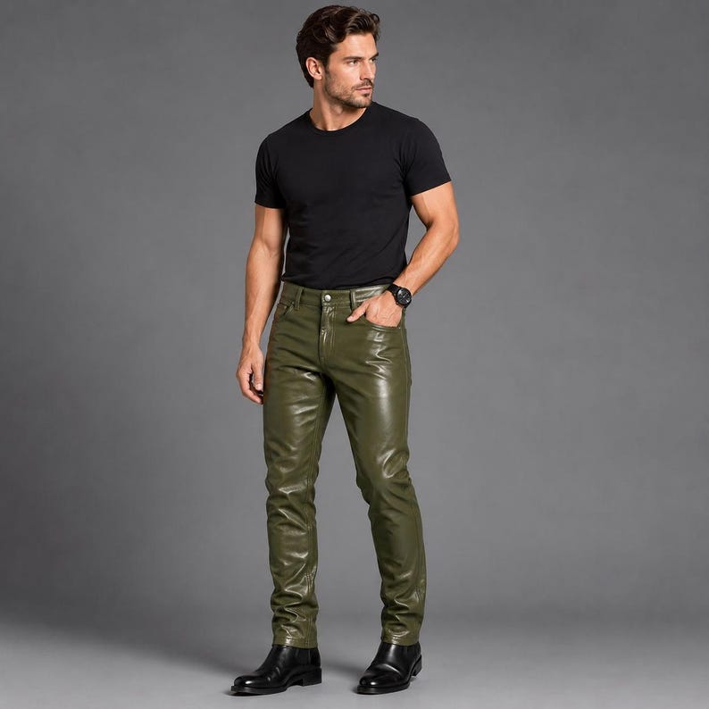 May include: A black short-sleeved crew neck t-shirt paired with olive green leather pants. The pants feature a classic five-pocket design with a button and zipper fly closure. The outfit is completed with black leather shoes and a black wristwatch.