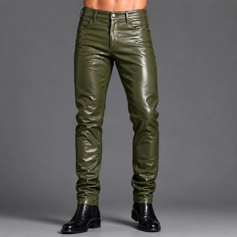 May include: Olive green pants with a glossy, smooth finish and a five-pocket design. These pants feature a button closure, a zippered fly, and belt loops at the waistband. The fit is slim through the legs, ending at the ankles above black boots.