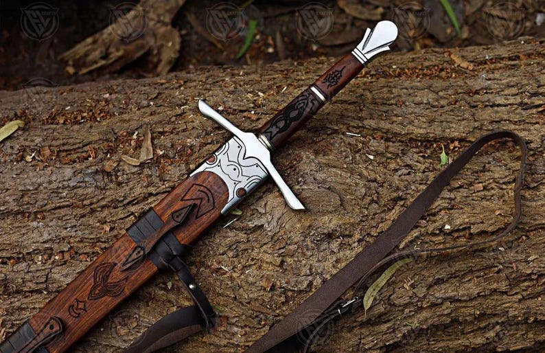 Puede incluir: Imagen detallada de una espada con empu&ntilde;adura y vaina de madera, apoyada sobre un tronco. La espada presenta una hoja y una guarda plateadas, con intrincadas tallas en la empu&ntilde;adura y la vaina. Una correa de cuero se encuentra cerca.