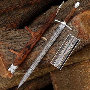 May include: A handcrafted sword with a silver blade and wooden handle, resting on a wooden log. The sword is accompanied by a leather sheath with decorative carvings. A rectangular piece of wood with a unique pattern is also present.